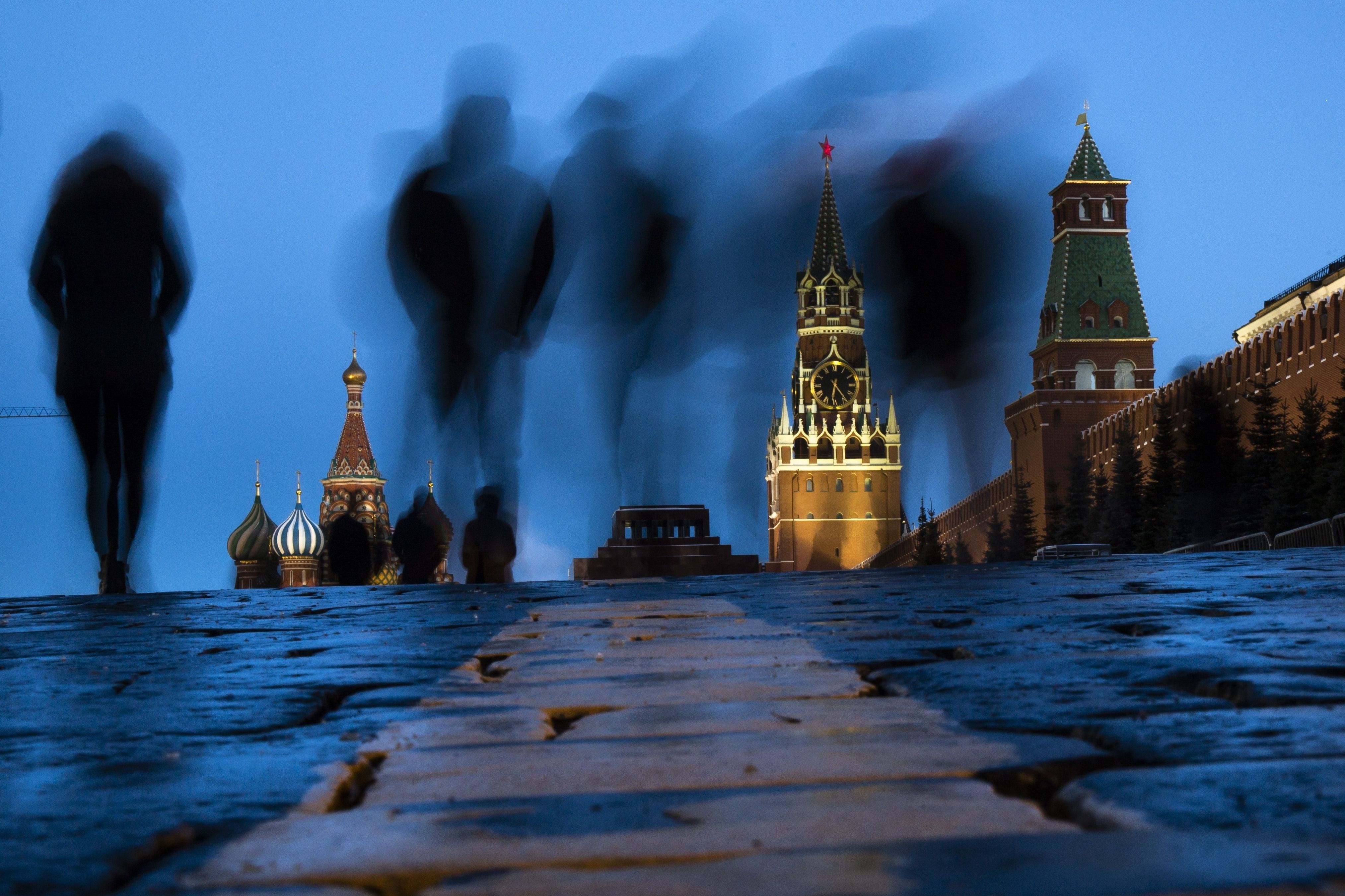 People walk through Red Square after sunset in Moscow